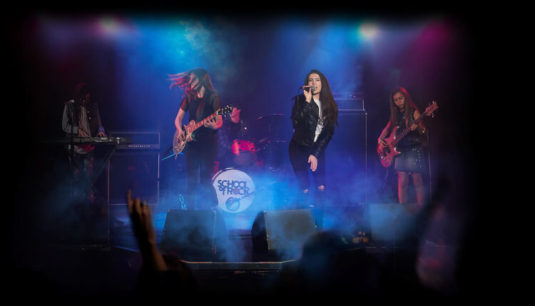 Alunos tocando em uma banda no palco