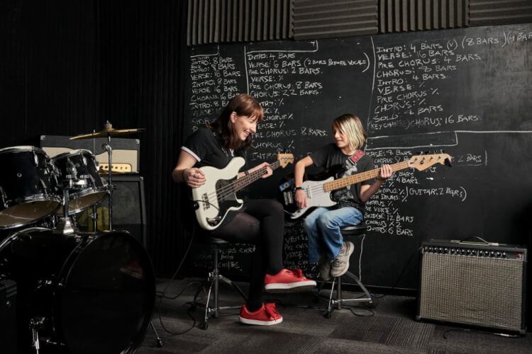 Guitar teacher playing guitar with student